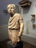 Scultura in pietra raffigurante un giovane servitore, da un monumento funerario della necropoli. H 64 cm, IV - III secolo a.C., da Taranto. Berlino, Altes Museum
